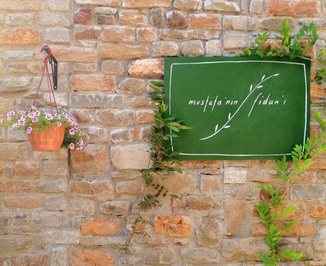 Η πινακίδα του ξενοδοχείου στον πέτρινο τοίχο